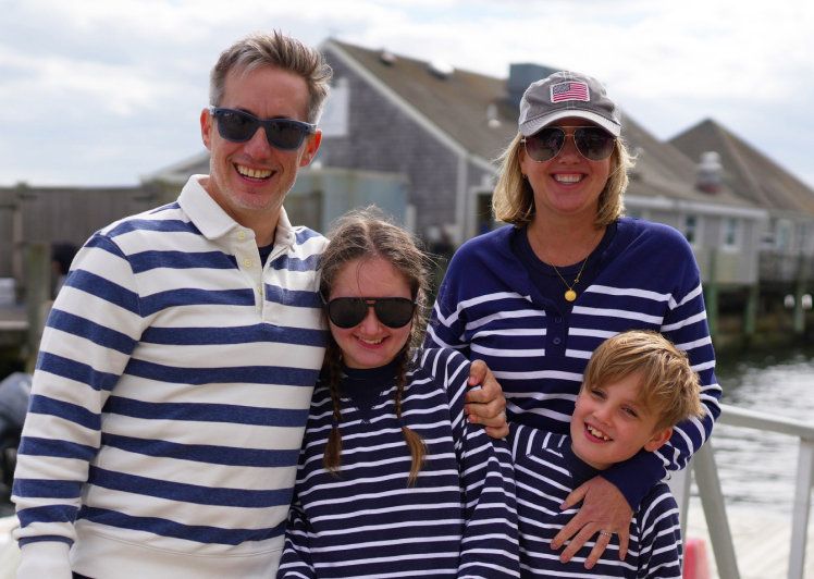 Family posing together at a marina before adaptive sailing