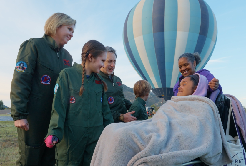 Families gathered beside a hot air balloon before takeoff