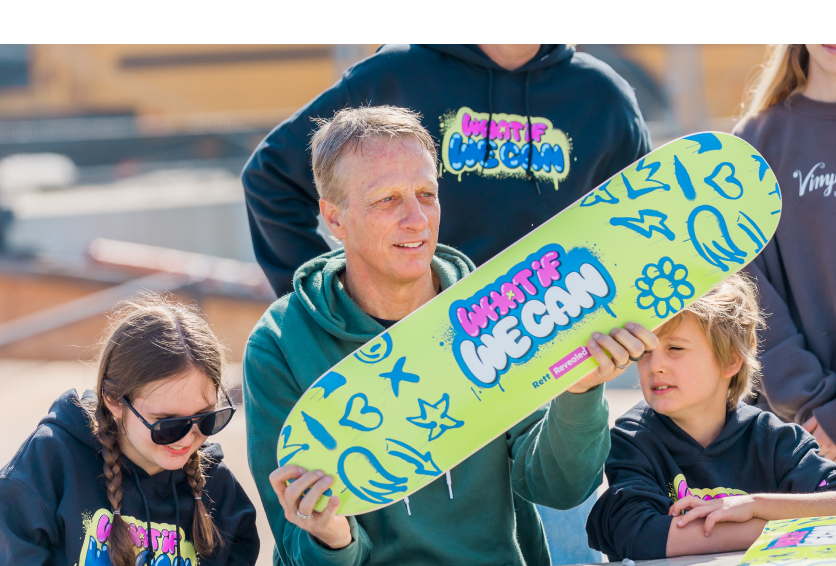 Tony Hawk posing with a family during an adaptive skateboarding event